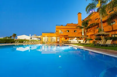 a large swimming pool in front of a building at Hotel Praia Sol in Quarteira