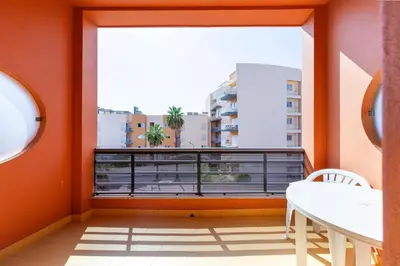 a balcony with a table and a large window at Hotel Praia Sol in Quarteira