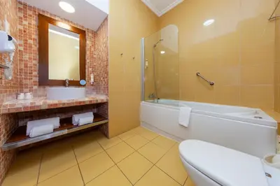 a bathroom with a tub and a toilet and a sink at Hotel Praia Sol in Quarteira