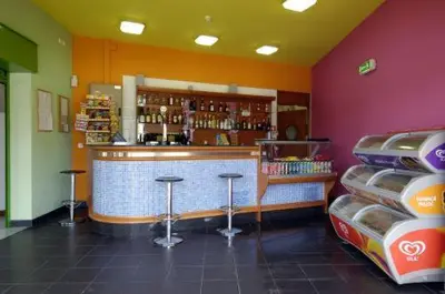 a restaurant with a bar and stools in a room at Orada Apartamentos Turísticos - Marina de Albufeira in Albufeira