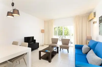 a bedroom with a blue bed and a blue chair at Vale Do Lobo Resort in Vale do Lobo