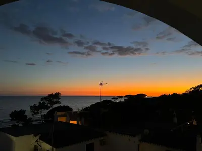a sunset view of the ocean from a building at Apartamentos Do Parque in Albufeira