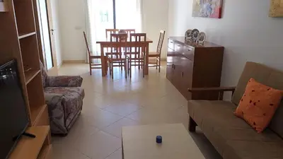 a living room with a couch and a table at T2 Tahíti - Terraço, Familiar, Garagem, Wifi in Quarteira