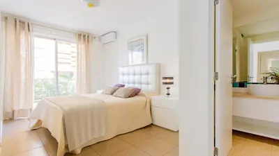 a white bedroom with a bed and a sink at Varandas de Carteia G/F in Quarteira