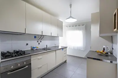 a kitchen with white cabinets and a sink at Apartamento Gulbenkian in Faro