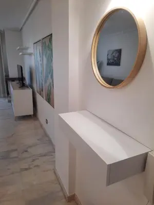 a white table with a mirror on a wall at Apartamento Falésia by Garvetur in Albufeira