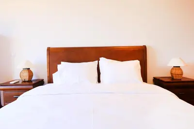 a bedroom with a large white bed with two lamps at Balaia Harmonia in Albufeira