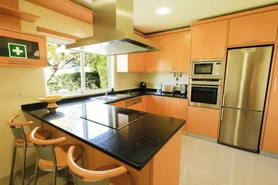 a kitchen with orange cabinets and a black counter top at Balaia Harmonia in Albufeira
