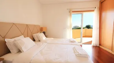 a white bed with white sheets and pillows in a bedroom at Balaia Harmonia in Albufeira