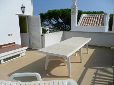 a picnic table on the roof of a house at Casa na praia e golfe in Vale do Lobo