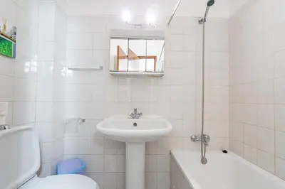 a table with a bowl of utensils and two chairs at Apartamento Stª Eulália Deluxe by Umbral in Albufeira