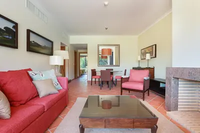 a living room with a red couch and a fireplace at Golf F5 by Garvetur in Vilamoura