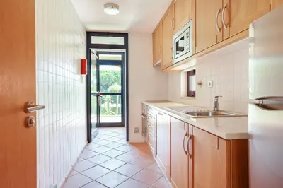 a kitchen with a sink and a door to a hallway at Golf F5 by Garvetur in Vilamoura
