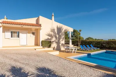 a villa with a swimming pool in front of a house at Villa Costa by Gabi Miguel in Albufeira