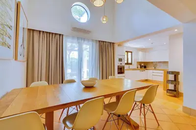 a kitchen and dining room with a wooden table and chairs at Pine Cliffs Village in Albufeira