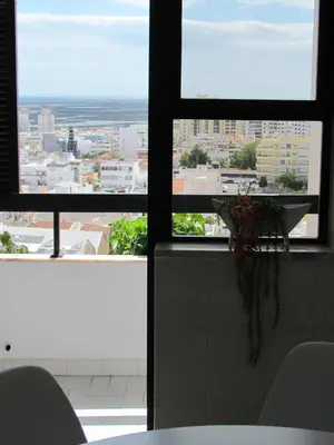 a kitchen with a view of a city from a window at In Faro with Sea View in Faro