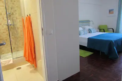 a bedroom with a bed and a glass shower at In Faro with Sea View in Faro
