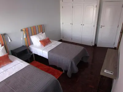 a small bedroom with two beds and a table at In Faro with Sea View in Faro