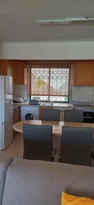 a kitchen with a table and chairs and a refrigerator at Apartamento Solar dos Pinheiros in Vilamoura
