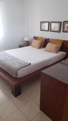 a bedroom with a large bed with white sheets and pillows at Apartamento Solar dos Pinheiros in Vilamoura