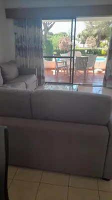 a couch in a living room with a view of a patio at Apartamento Solar dos Pinheiros in Vilamoura