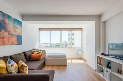 a living room with a couch and a tv at Vista Mar in Quarteira