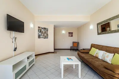 a living room with a couch and a tv at Algamar by Garvetur in Vilamoura
