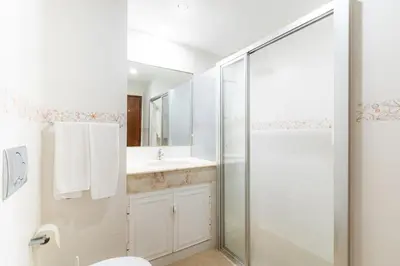 a white bathroom with a shower and a sink at Algamar by Garvetur in Vilamoura