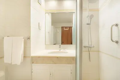 a white bathroom with a sink and a mirror at Algamar by Garvetur in Vilamoura