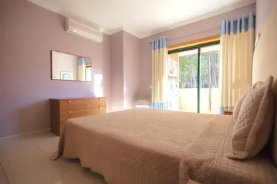 a bedroom with a bed and a large window at Eden Vilage by Garvetur in Vilamoura
