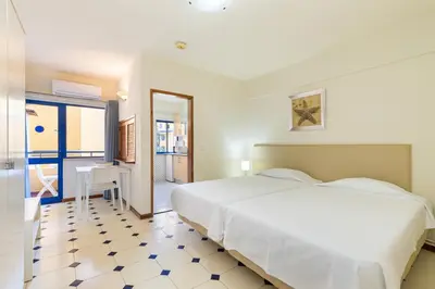 a bedroom with a large white bed and a table at Rio by Garvetur in Vilamoura