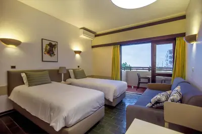 a hotel room with two beds and a couch at Turial Old Town Ocean View in Albufeira