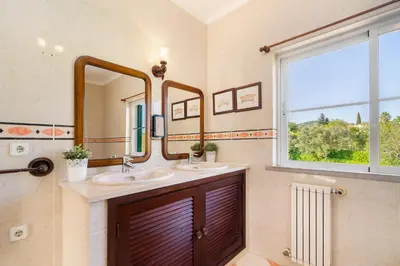 a bathroom with two sinks and a window at Quinta das Figueiras - Bordeira - Faro in Bordeira