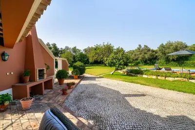 a stone walkway next to a house with a yard at Quinta das Figueiras - Bordeira - Faro in Bordeira