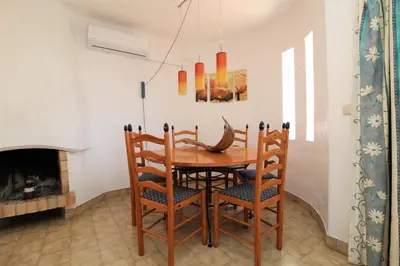 a dining room with a wooden table and chairs at Apartamento 53A São Rafael T2 duplex - Albufeira, Algarve in Albufeira