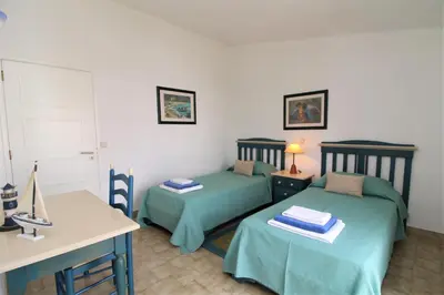 two beds in a room with a table and a desk at Apartamento 53A São Rafael T2 duplex - Albufeira, Algarve in Albufeira