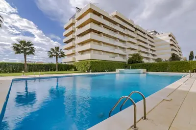 a swimming pool in front of a building at São Vicente - 1Br - Facing to Marina in Quarteira