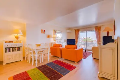 a living room with a table and chairs and a dining room at São Vicente - 1Br - Facing to Marina in Quarteira