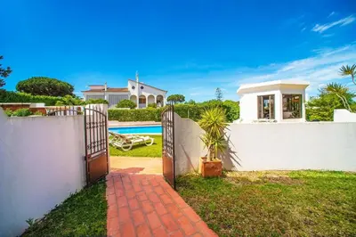 a gate leading to a house with a pool at 2 Bed Ground Floor Apartment In Vilamoura in Vilamoura