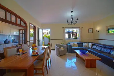a living room with a blue couch and a table at 2 Bed Ground Floor Apartment In Vilamoura in Vilamoura