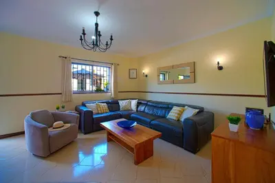 a living room with a blue couch and a table at 2 Bed Ground Floor Apartment In Vilamoura in Vilamoura