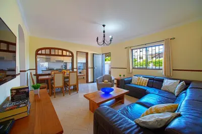 a living room with a blue couch and a table at 2 Bed Ground Floor Apartment In Vilamoura in Vilamoura