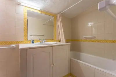 a bathroom with a sink and a mirror and a tub at Villa Morena in Albufeira