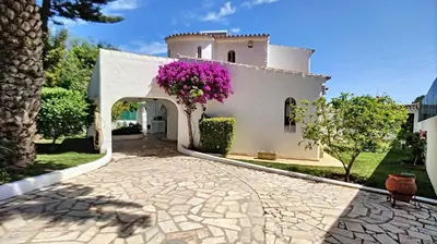 a white house with purple flowers on the side of it at Villa Palmeira Galé Beach in Albufeira
