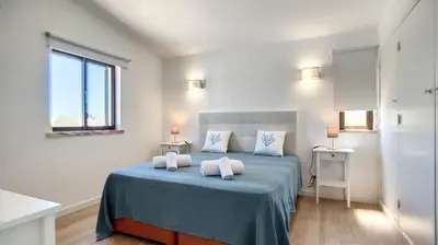 a bedroom with a blue bed with two white pillows at Villa Palmeira Galé Beach in Albufeira
