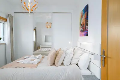 a white bedroom with a bed with white pillows at Old Village & Prestige in Vilamoura