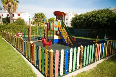 a colorful fence with a playground in a park at Old Village & Prestige in Vilamoura