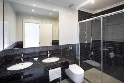 a bathroom with two sinks and a glass shower at Victory Village 3A in Quinta do Lago