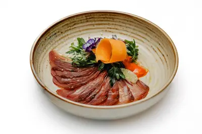 a bowl of food with oranges and vegetables on it at Aqua Pedra Dos Bicos Design Beach Hotel - Adults Friendly in Albufeira