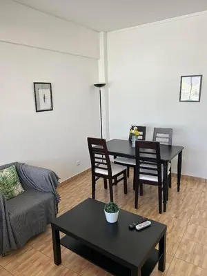 a living room with a couch and a table and chairs at Brother´s House in Faro
